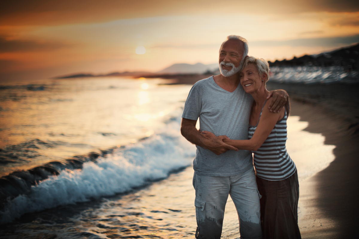 Senior couple standing on the beach at late sunset. Age means nothing