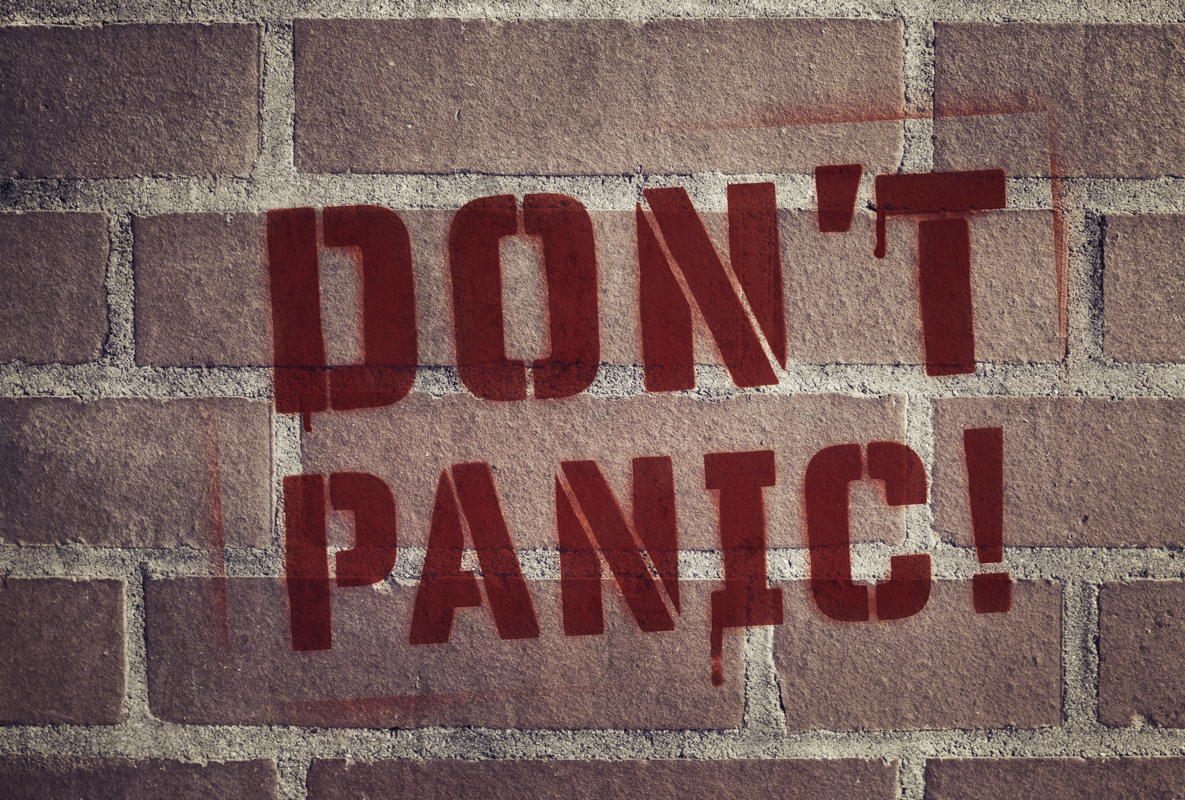 "Don't Panic!" Stencil Spray-Painted on Brick Wall