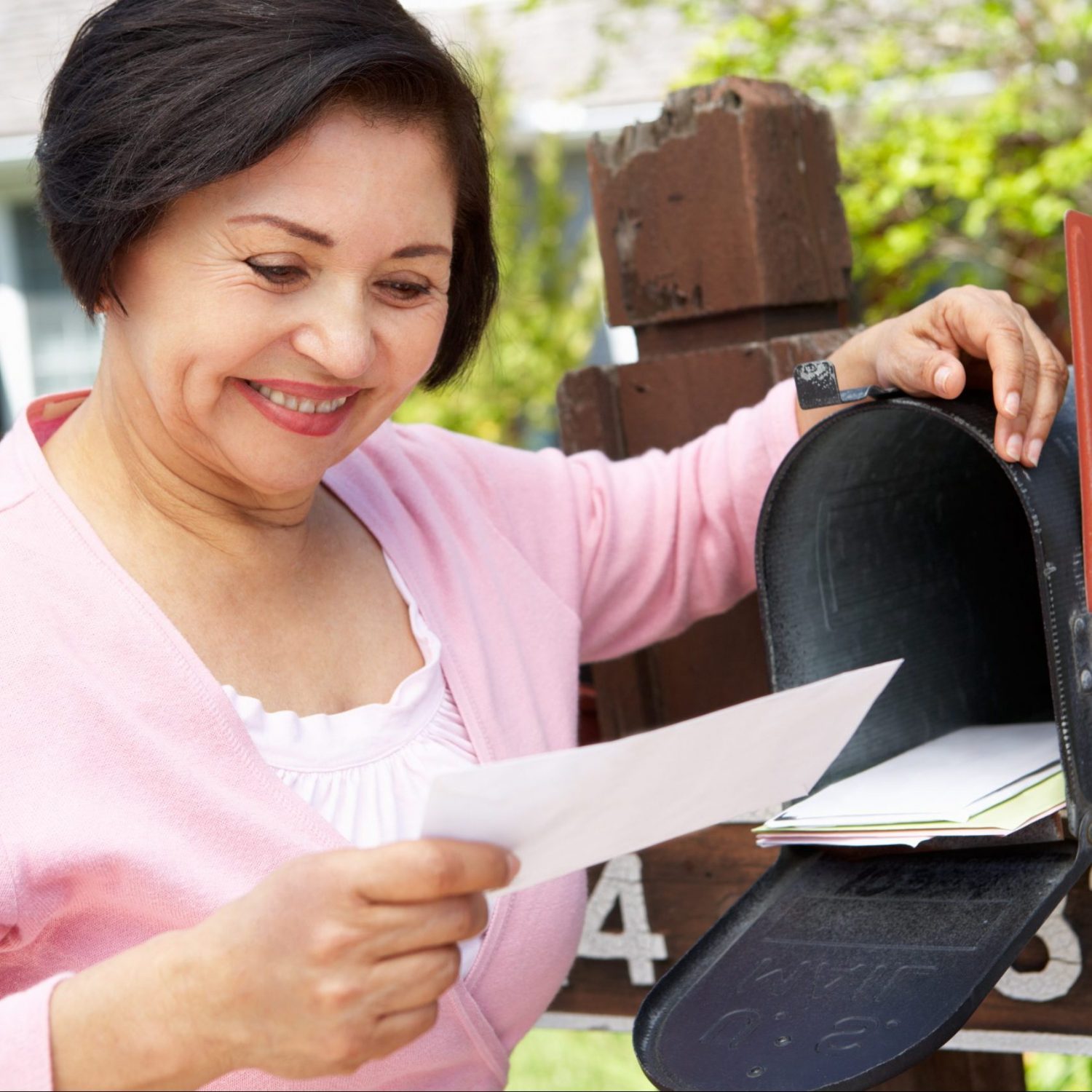senior woman checks mailbox for mail