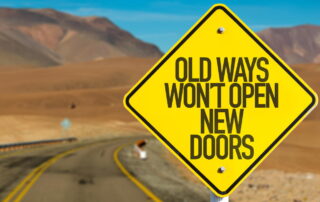 desert highway with a sign saying Old Ways Wont Open New Doors to represent change
